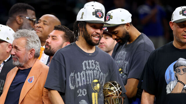 SAN ANTONIO, TEXAS - JUNE 13: Jalen Brunson #11 of the New York Knicks celebrates with the Bill Russell NBA Finals Most Valuable Player Award trophy and his father Rick Brunson after defeating the San Antonio Spurs in Game Five of the 2026 NBA Finals at Frost Bank Center on June 13, 2026 in San Antonio, Texas.