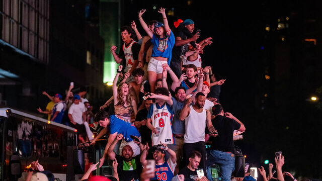 NEW YORK, NEW YORK - JUNE 14: New York Knicks fans climb on buses as they celebrate after they win the NBA Finals in Times Square on June 14, 2026 in New York City. The New York Knicks lead the San Antonio Spurs 3-1 and could win the franchise's first NBA championship since 1973 if they win tonight.