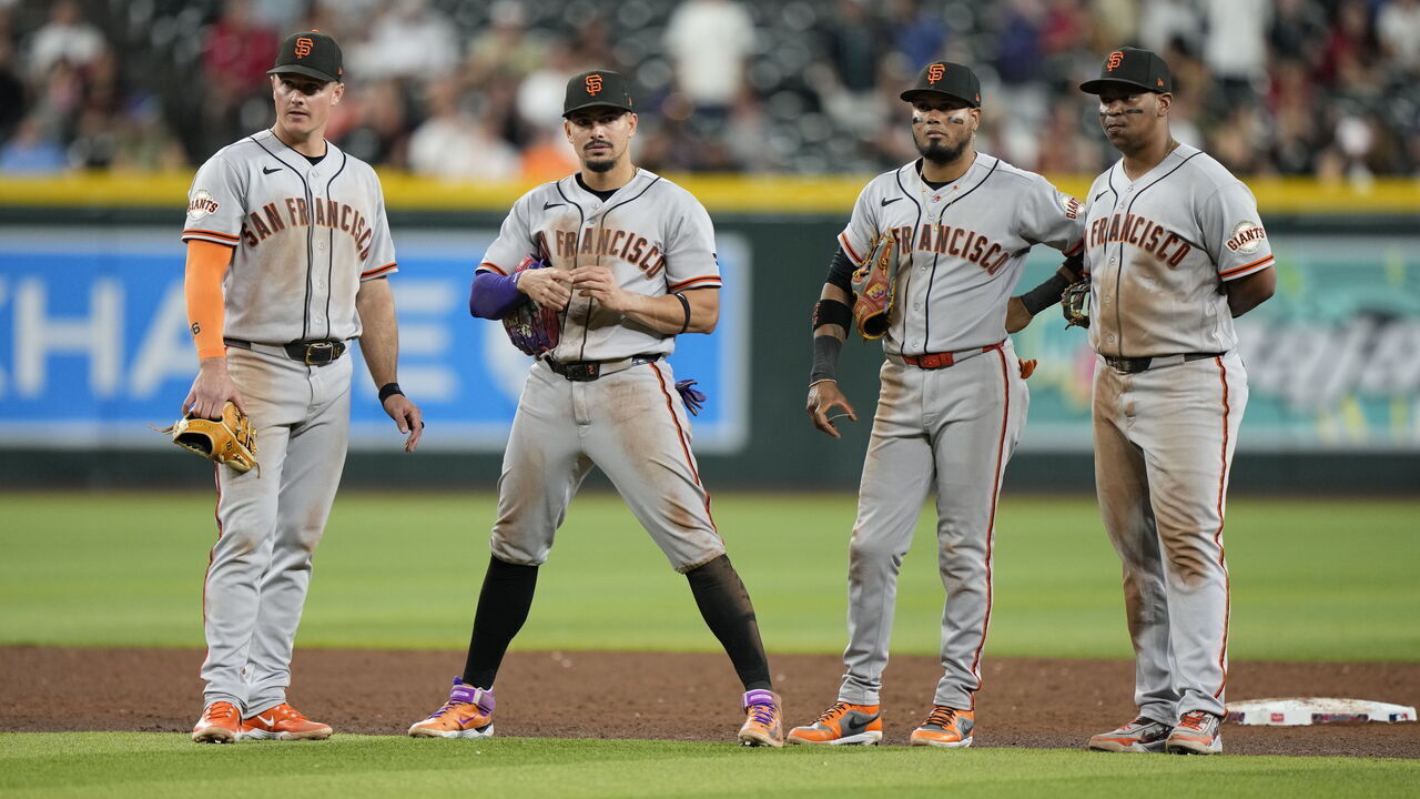 PHOENIX, ARIZONA - MAY 19: Matt Chapman #26, Willy Adames #2, Luis Arraez #1 and Rafael Devers #16 of the San Francisco Giants talk during a mound visit at Chase Field on May 19, 2026 in Phoenix, Arizona.