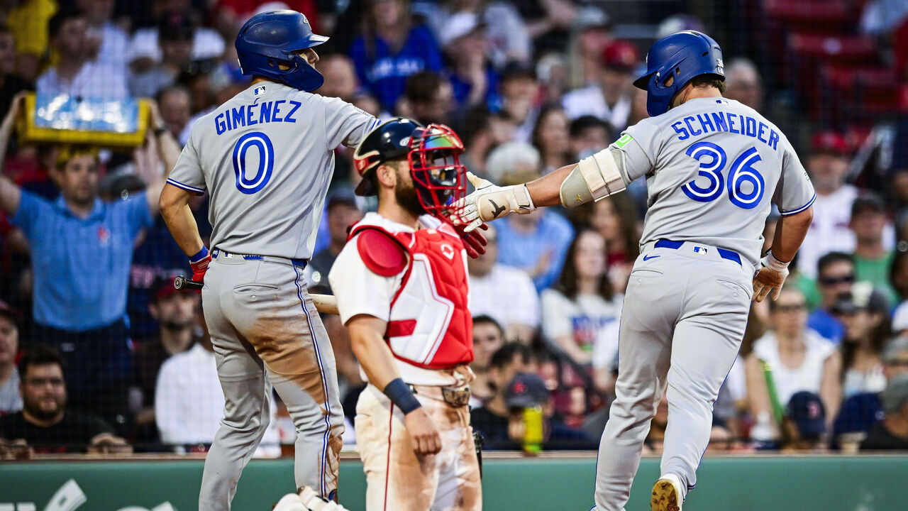 BOSTON, MASSACHUSETTS - JUNE 16: Davis Schneider #36 of the Toronto Blue Jays is greeted at home plate by Andrés Giménez #0 after hitting a solo home run in the fifth inning against the Boston Red Sox at Fenway Park on June 16, 2026 in Boston, Massachusetts.