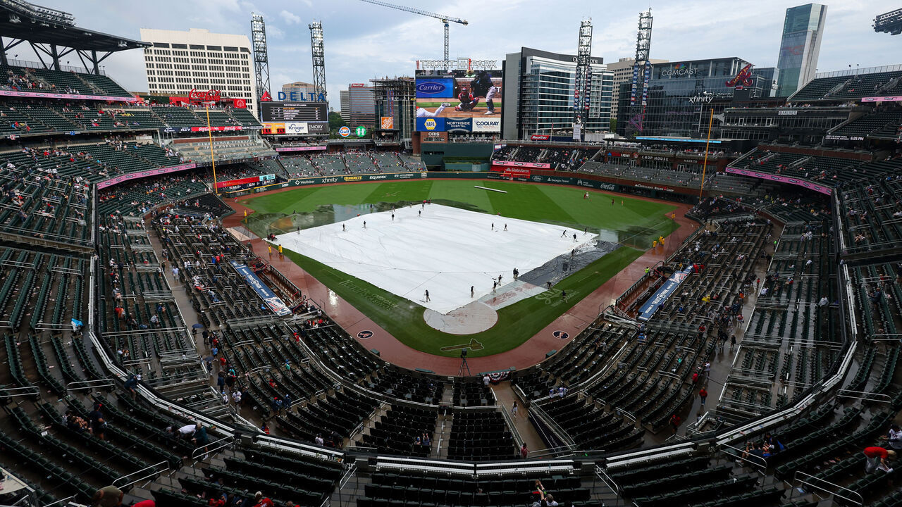 ATLANTA, GEORGIA - MAY 24: The tarp covers the field during a rain delay in a game between the Atlanta Braves and Washington Nationals in the seventh inning at Truist Park on May 24, 2026 in Atlanta, Georgia.
