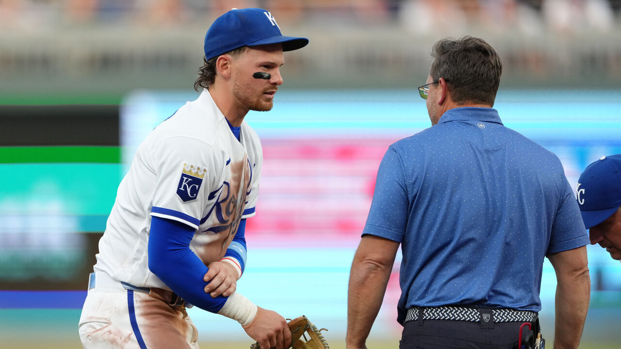 KANSAS CITY, MISSOURI - JUNE 18: Bobby Witt Jr. #7 of the Kansas City Royals is attended to by a team trainer after making a play against the St. Louis Cardinals in the fourth inning at Kauffman Stadium on June 18, 2026 in Kansas City, Missouri.