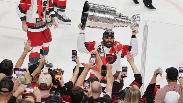 LAS VEGAS, NEVADA - JUNE 14: Jordan Martinook #48 of the Carolina Hurricanes carries the Stanley Cup by fans after the team's 3-0 victory over the Vegas Golden Knights in Game Six of the 2026 NHL Stanley Cup Final at T-Mobile Arena on June 14, 2026 in Las Vegas, Nevada. The Hurricanes won the series four games to two.