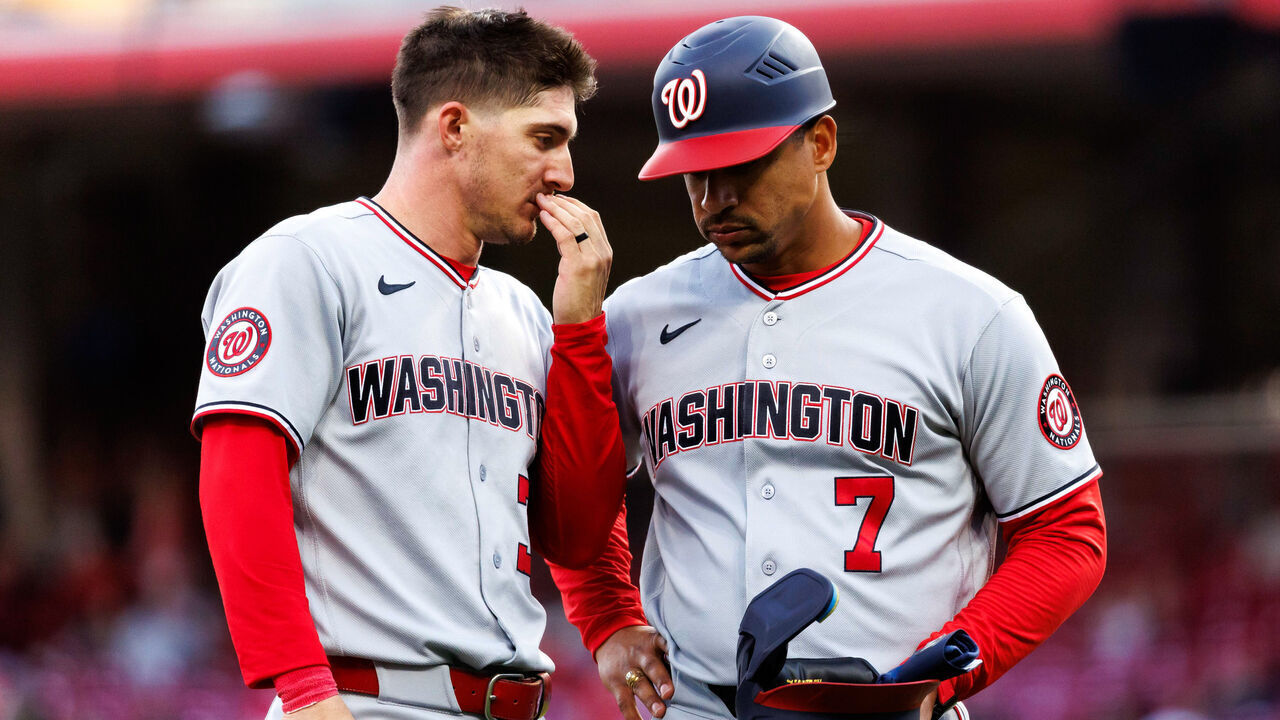 CINCINNATI, OHIO - MAY 13: Jacob Young #30 talks to Victor Estevez #7 of the Washington Nationals after the top outfield the fourth inning against the Cincinnati Reds at Great American Ball Park on May 13, 2026 in Cincinnati, Ohio.