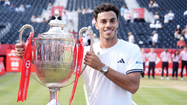 Francisco Cerundolo of Argentina celebrates with the trophy after winning the men's singles final against Tommy Paul of the United States on day fourteen of the HSBC Championships at The Queen's Club, London. Picture date: Saturday June 21, 2026.