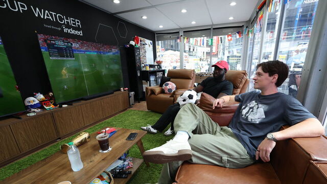 Austin Franklin (right) and Kevin Akoto watch a 2026 World Cup match between Portugal and Uzbekistan from their transparent cube in Times Square in New York, on June 23, 2026. The pair being paid $50,000 by FOX, one of the tournament's broadcasters, were selected from a field of thousands of eager fans after submitting video applications, to watch every one of the 104 games of the World Cup.