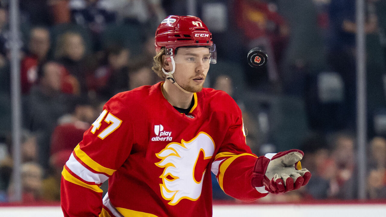 CALGARY, CANADA - APRIL 14: Connor Zary #47 of the Calgary Flames tosses a puck to a linesman during the first period of a game against the Colorado Avalanche at the Scotiabank Saddledome on April 14, 2026 in Calgary, Canada.