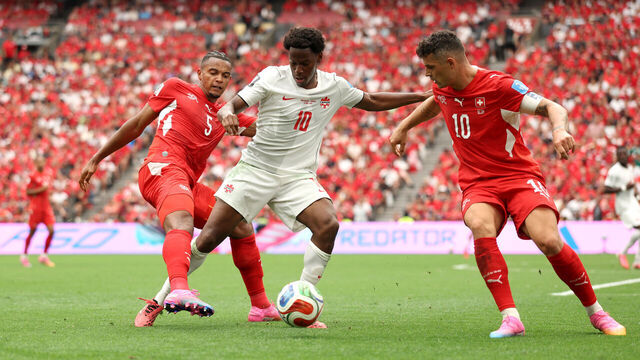 VANCOUVER, BRITISH COLUMBIA - JUNE 24: Jonathan David #10 of Canada competes for the ball against Manuel Akanji #5 and Granit Xhaka #10 of Switzerland during the FIFA World Cup 2026 Group B match between Switzerland and Canada at BC Place Vancouver on June 24, 2026 in Vancouver, British Columbia.