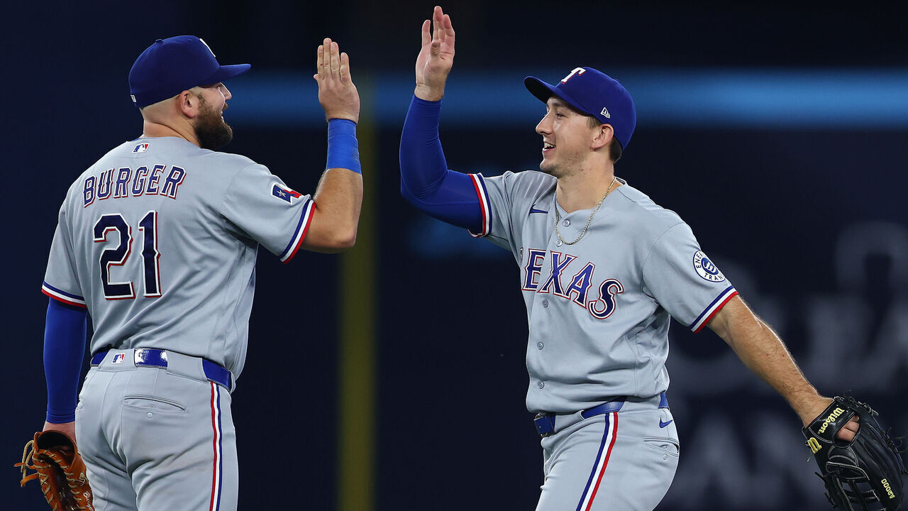 TORONTO, ON - JUNE 25: Wyatt Langford #36 of the Texas Rangers celebrates the win with Jake Burger #21 after a game against the Toronto Blue Jays at Rogers Centre on June 25, 2026 in Toronto, Ontario, Canada.