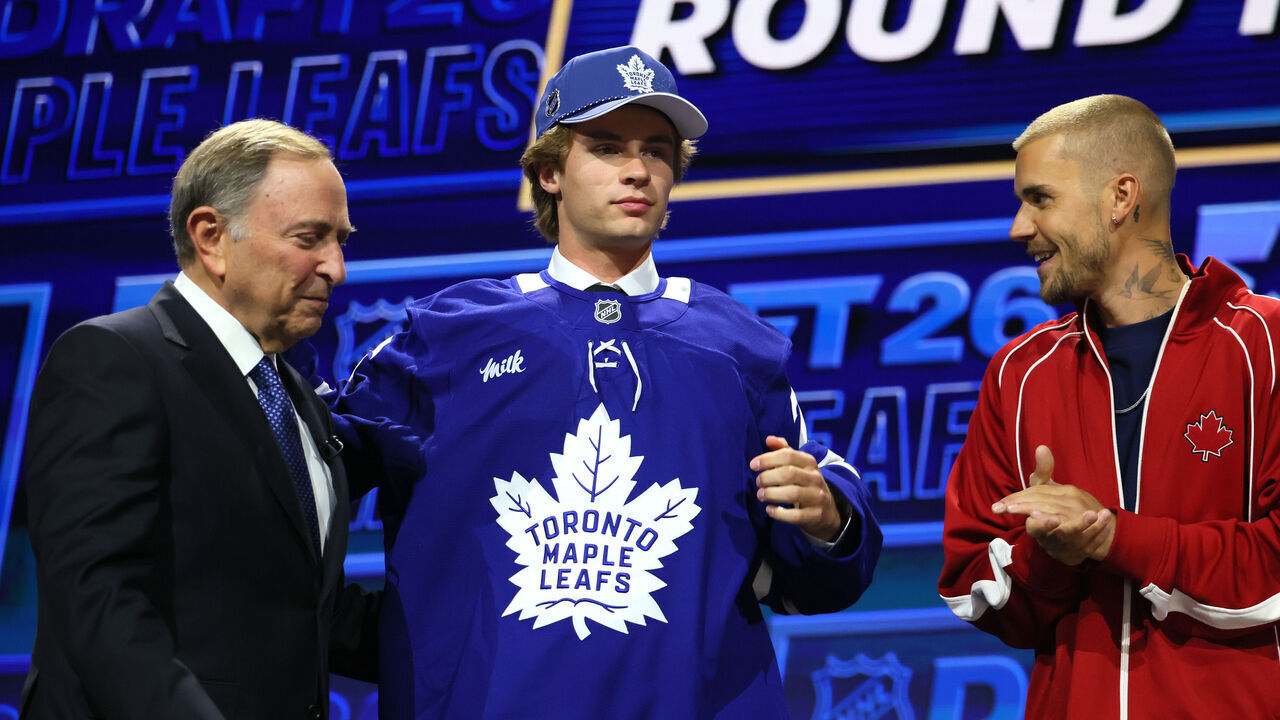 BUFFALO, NEW YORK - JUNE 26: (L-R) NHL commissioner Gary Bettman looks on as Gavin McKenna of Canada and singer Justin Bieber look on after McKenna was drafted by the Toronto Maple Leafs with the first overall pick during day one of the 2026 NHL Draft on June 26, 2026 in Buffalo, New York.