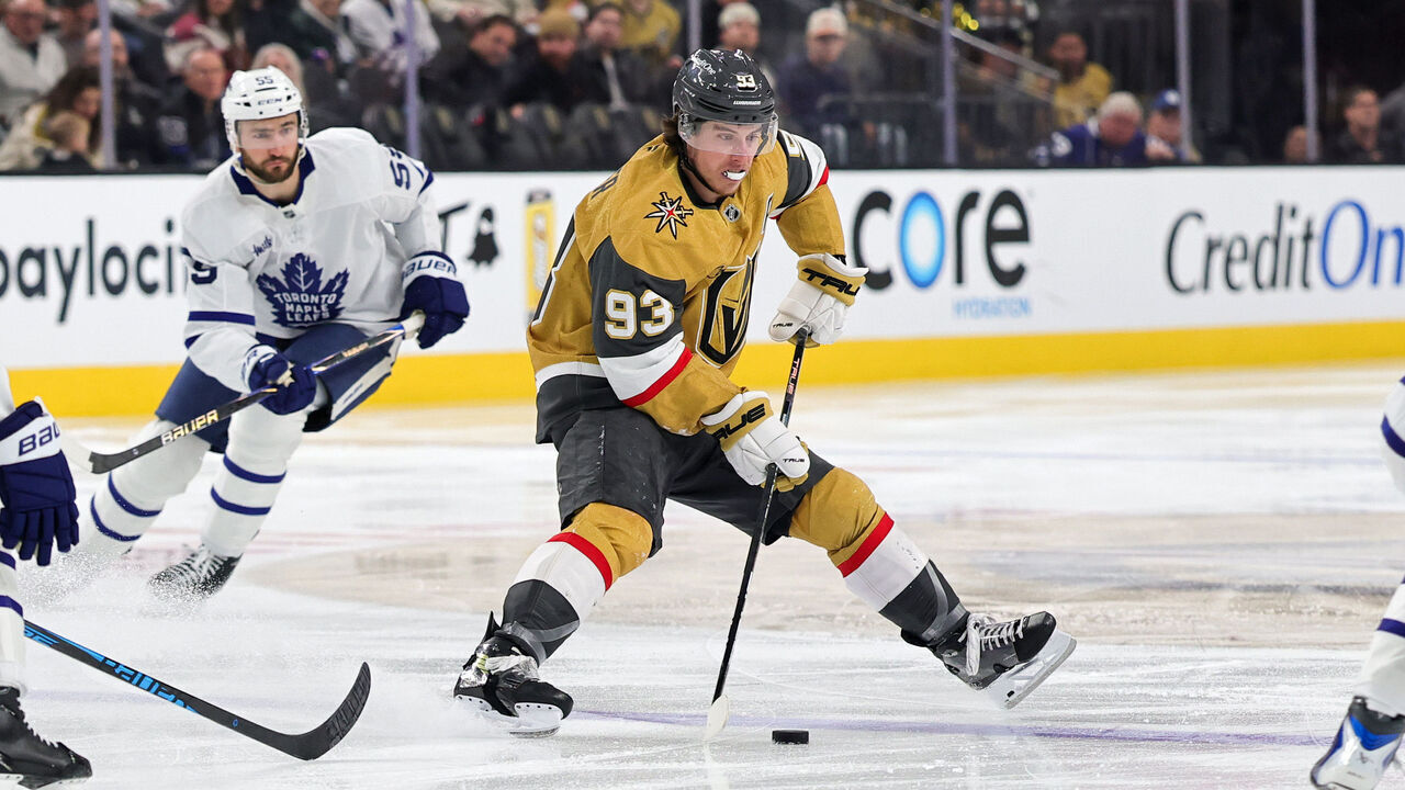 LAS VEGAS, NEVADA - JANUARY 15: Mitch Marner #93 of the Vegas Golden Knights skates with the puck against Philippe Myers #51 and Auston Matthews #34 of the Toronto Maple Leafs in the second period of their game at T-Mobile Arena on January 15, 2026 in Las Vegas, Nevada.