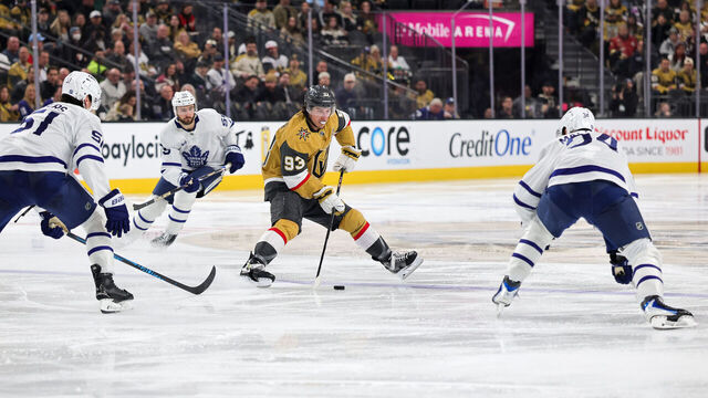 LAS VEGAS, NEVADA - JANUARY 15: Mitch Marner #93 of the Vegas Golden Knights skates with the puck against Philippe Myers #51 and Auston Matthews #34 of the Toronto Maple Leafs in the second period of their game at T-Mobile Arena on January 15, 2026 in Las Vegas, Nevada.