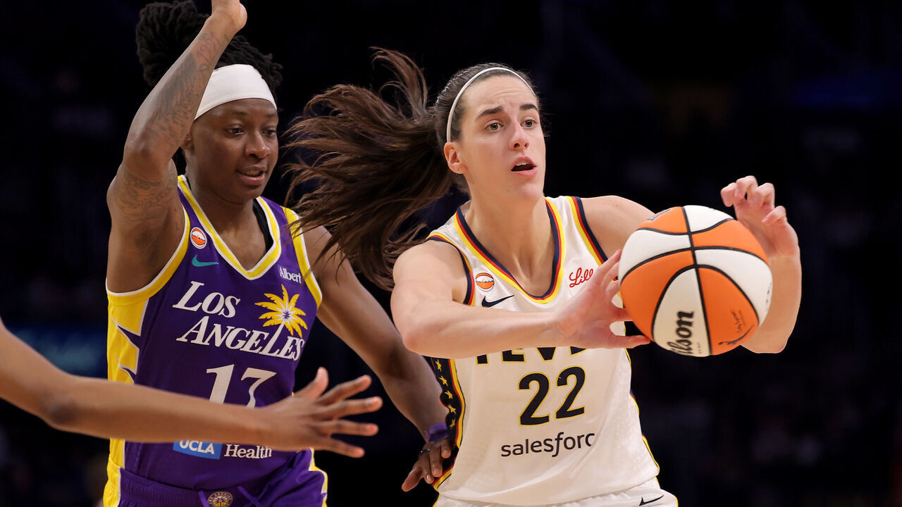 LOS ANGELES, CALIFORNIA - JULY 08: Caitlin Clark #22 of the Indiana Fever passes the ball against Erica Wheeler #17 of the Los Angeles Sparks during the fourth quarter of the game at Crypto.com Arena on July 08, 2026 in Los Angeles, California. NOTE TO USER: User expressly acknowledges and agrees that, by downloading and/or using this Photograph, user is consenting to the terms and conditions of the Getty Images License Agreement.