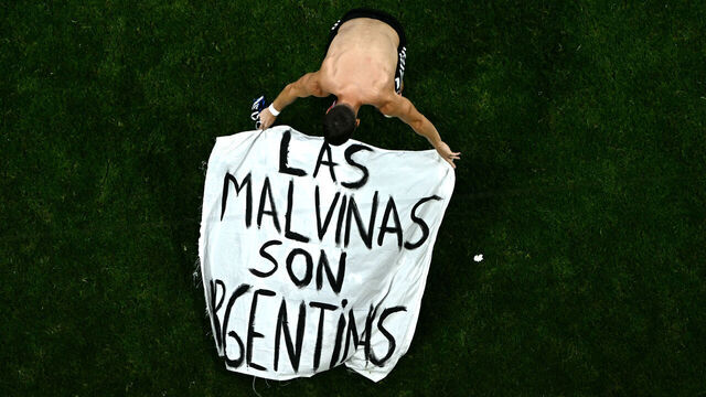 TOPSHOT - Argentina's midfielder #11 Giovani Lo Celso adjusts a banner reading "The Malvinas (Falkland Islands) belong to Argentina," after winning the 2026 World Cup football tournament semi-final match between England and Argentina at the Atlanta Stadium in Atlanta on July 15, 2026.