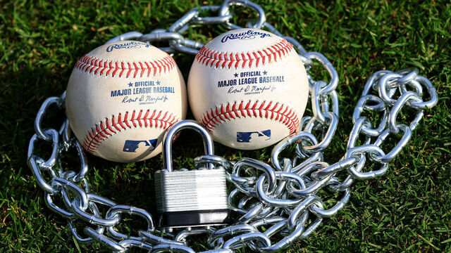 ATLANTA, GA - MAY 13: A locked padlock and chain against two official MLB baseballs representing a potential lockout between Major League Baseball (MLB) and the Major League Baseball Players Association (MLBPA) for the 2027 MLB season, as photographed on May 13, 2026 in Atlanta, GA.