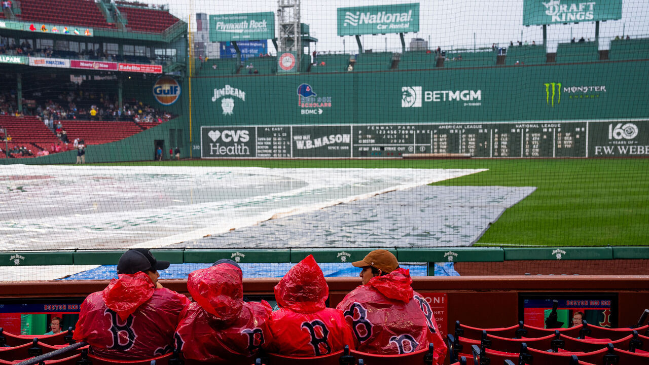 BOSTON, MASSACHUSETTS - JULY 18: Fans wait through a rain delay prior to a game between the Tampa Bay Rays and the Boston Red Sox at Fenway Park on July 18, 2026 in Boston, Massachusetts.