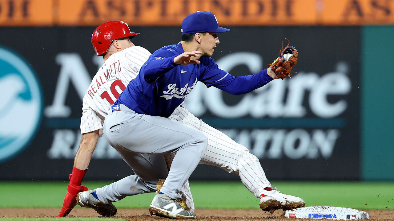 PHILADELPHIA, PENNSYLVANIA - JULY 21: Tommy Edman #25 of the Los Angeles Dodgers tags out J.T. Realmuto #10 of the Philadelphia Phillies at second base for a double play in the ninth inning at Citizens Bank Park on July 21, 2026 in Philadelphia, Pennsylvania.