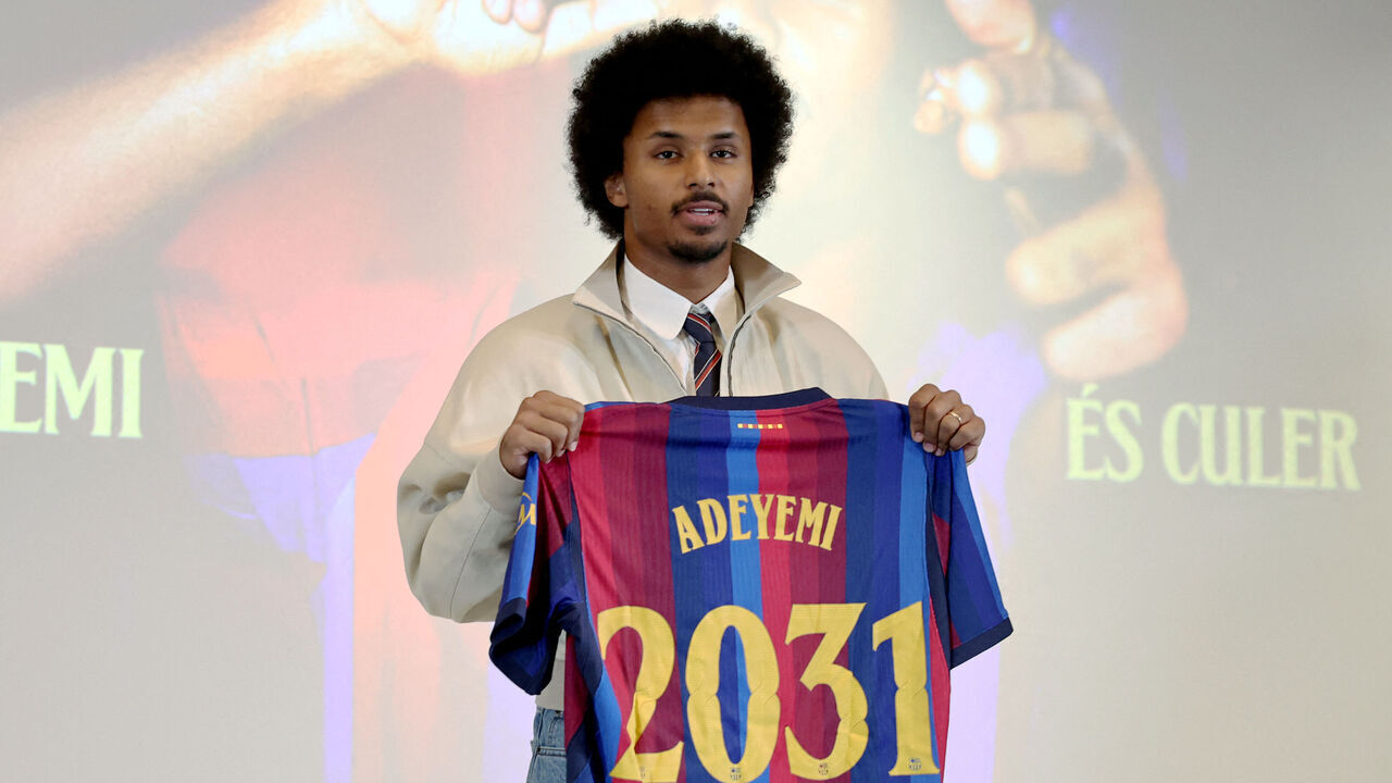 German footballer Karim Adeyemi poses with a jersey bearing his name during his official presentation as FC Barcelona's new player on July 23, 2026 in Barcelona. Barcelona signed forward Karim Adeyemi from Borussia Dortmund today for a reported fee of 29 million euros ($33 million) including potential add-ons.