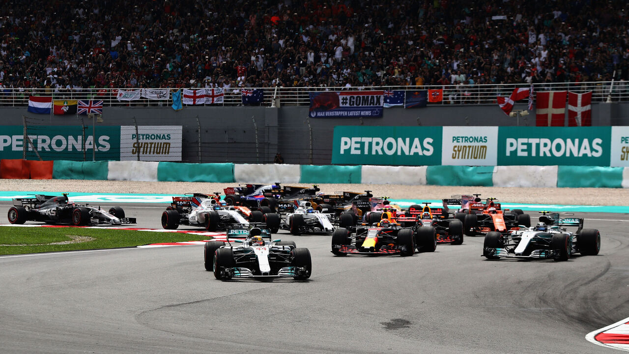 KUALA LUMPUR, MALAYSIA - OCTOBER 01: Lewis Hamilton of Great Britain driving the (44) Mercedes AMG Petronas F1 Team Mercedes F1 WO8 leads Max Verstappen of the Netherlands driving the (33) Red Bull Racing Red Bull-TAG Heuer RB13 TAG Heuer, Valtteri Bottas driving the (77) Mercedes AMG Petronas F1 Team Mercedes F1 WO8 and the rest of the field into turn two at the start during the Malaysia Formula One Grand Prix at Sepang Circuit on October 1, 2017 in Kuala Lumpur, Malaysia.