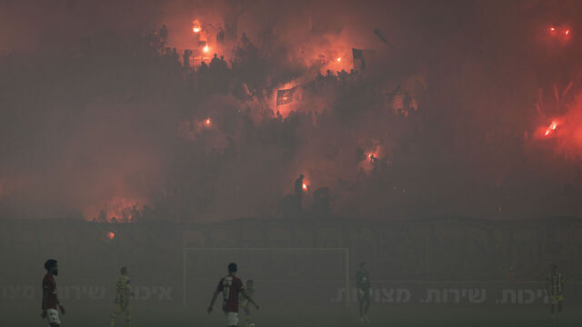 TOPSHOT - Maccabi Tel Aviv fans light pyrotechnics during the last derby match of the season against Hapoel Tel Aviv at Bloomfield Stadium in Tel Aviv on May 6, 2026.