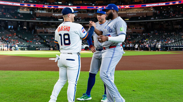 HOUSTON, TEXAS - AUGUST 03: (L-R) Daulton Varsho #18 of the Houston Astros speaks with George Springer #4 and Vladimir Guerrero Jr. #27 of the Blue Jays before the game at Daikin Park on August 03, 2026 in Houston, Texas.