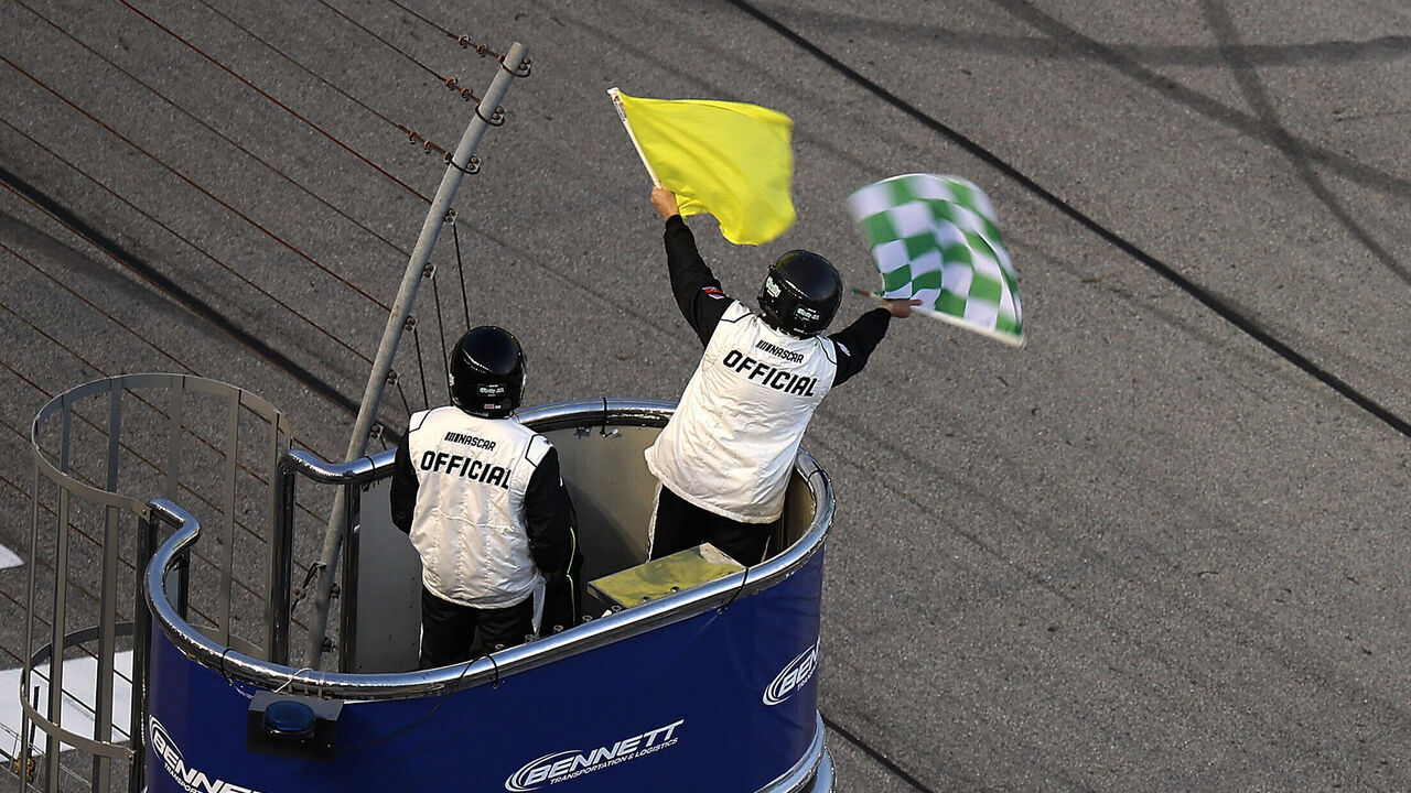 HAMPTON, GEORGIA - FEBRUARY 21: A NASCAR Official waves the caution and green-checkered flag to end stage two during the NASCAR O'Reilly Auto Parts Series Bennett Transportation & Logistics 250 at Echo Park Speedway on February 21, 2026 in Hampton, Georgia.