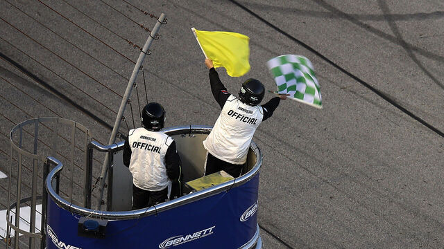 HAMPTON, GEORGIA - FEBRUARY 21: A NASCAR Official waves the caution and green-checkered flag to end stage two during the NASCAR O'Reilly Auto Parts Series Bennett Transportation & Logistics 250 at Echo Park Speedway on February 21, 2026 in Hampton, Georgia.