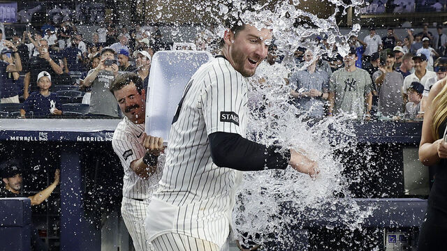 NEW YORK, NEW YORK - AUGUST 07: Ryan McMahon #19 of the New York Yankees is doused with water by teammate Austin Wells #28 after his tenth inning game winning sacrifice fly against the Atlanta Braves at Yankee Stadium on August 07, 2026 in New York City.