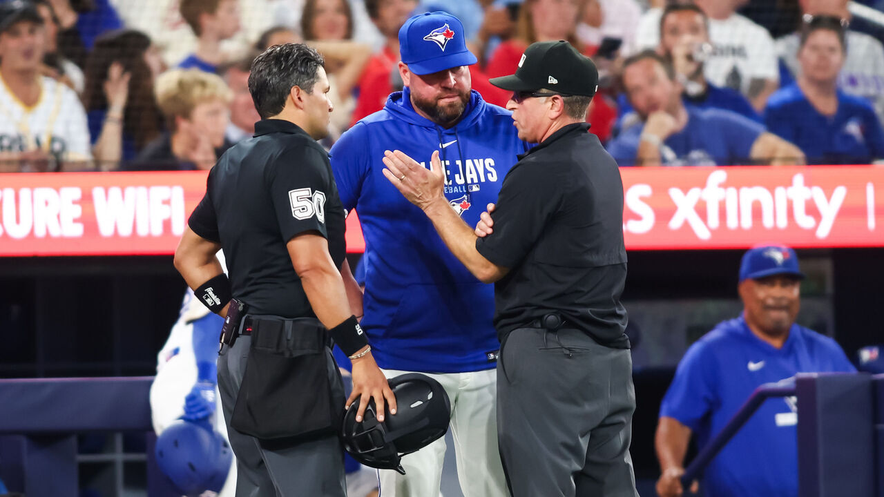 TORONTO, CANADA - AUGUST 10: Umpires explain a rule review to manager John Schneider of the Toronto Blue Jays during the seventh inning of their MLB game against the Boston Red Sox at Rogers Centre on August 10, 2026 in Toronto, Ontario, Canada.