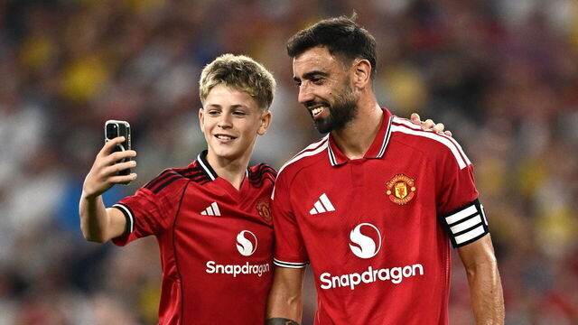 Dublin , Ireland - 12 August 2026; A pitch invader takes a selfie with Bruno Fernandes of Manchester United during the pre-season friendly match between Manchester United and Leeds United at Croke Park in Dublin.