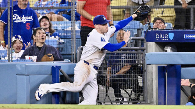 Los Angeles, - August 12: Freddie Freeman #5 of the Los Angeles Dodgers falls into the dugout while chasing a foul ball off the bat of Isaac Collins (not pictured) of the Kansas City Royals in the eighth inning of a baseball game at Dodger Stadium in Los Angeles on Wednesday, August 12, 2026.