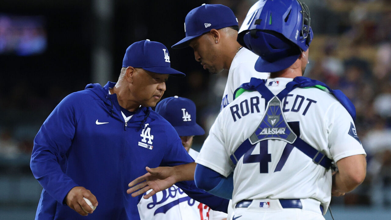 LOS ANGELES, CALIFORNIA - AUGUST 13: Dave Roberts #30 of the Los Angeles Dodgers takes the ball from Edwin Diaz #3, leaving the game after allowing two runs to score for a 4-4 tie against the Milwaukee Brewers, during the ninth inning at Dodger Stadium on August 13, 2026 in Los Angeles, California.