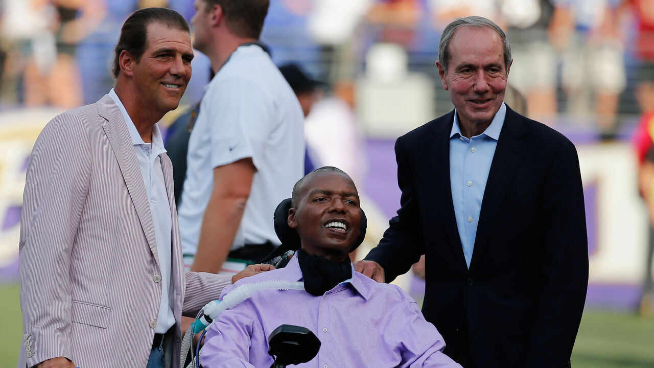BALTIMORE, MD - AUGUST 13: Baltimore Ravens owner Steve Bisciotti (L) and president Dick Cass (R) pose for a photo with former Ravens player O.J. Brigance before the start of a preseason game against the New Orleans Saints at M&T Bank Stadium on August 13, 2015 in Baltimore, Maryland.