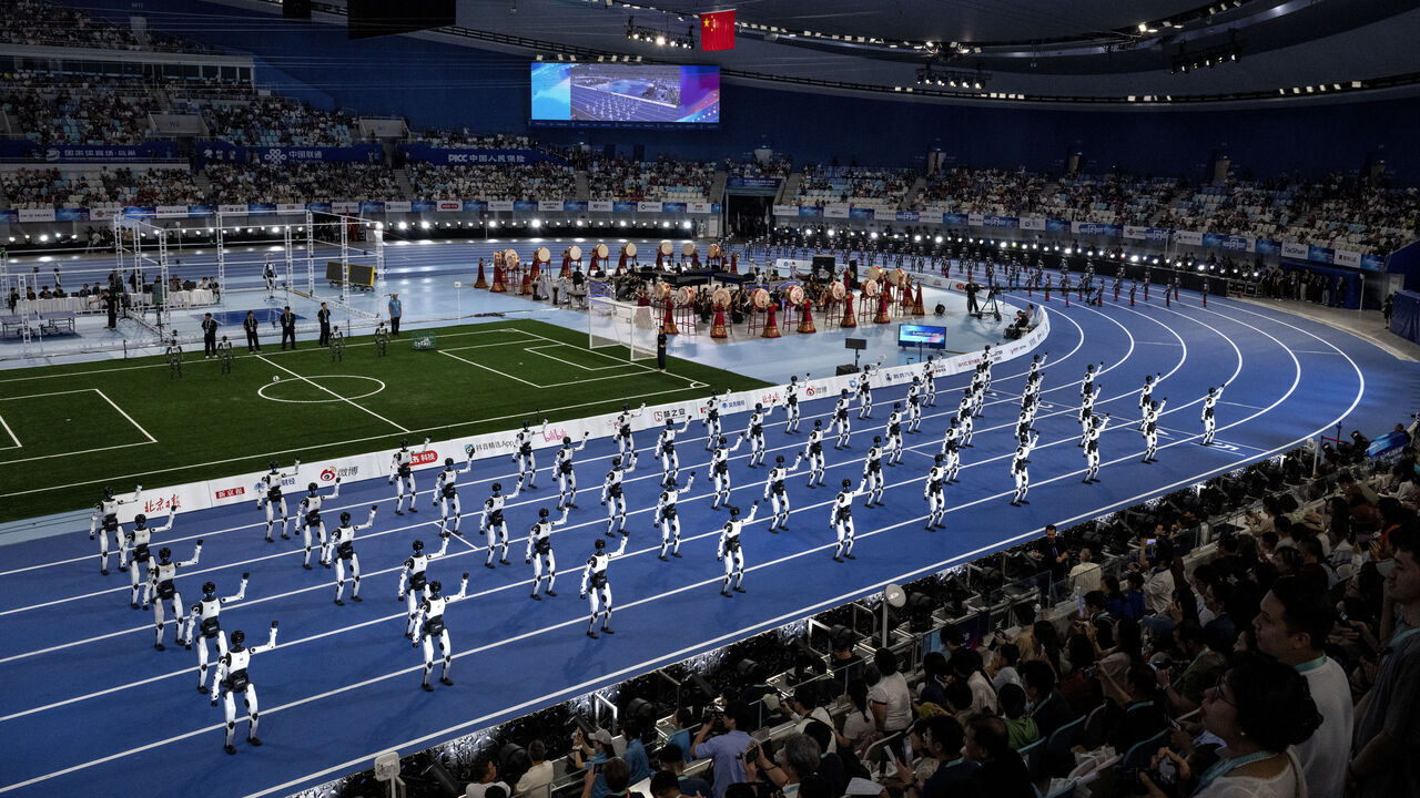 BEIJING, CHINA - AUGUST 22: Humanoid robots perform at the opening of the 2nd World Robot Games at National Speed Skating Oval on August 22, 2026 in Beijing, China. The games, that feature hundreds of humanoid robots competing in track and field, tennis, boxing, football, working skills among many others, runs from August 22-26th.