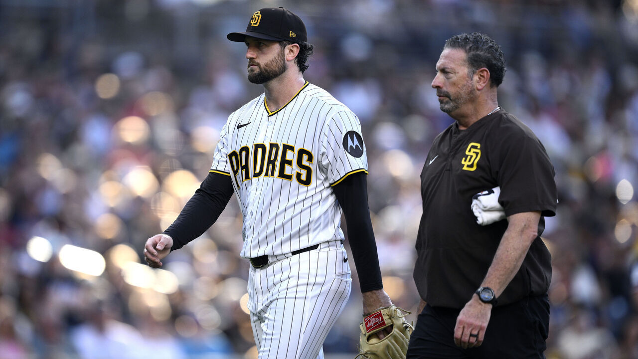SAN DIEGO, CALIFORNIA - AUGUST 22: Casey Mize #32 of the San Diego Padres walks to the dugout with a trainer after a pitching change in the third inning against the Minnesota Twins at Petco Park on August 22, 2026 in San Diego, California.