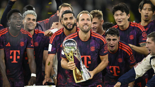 Bayern Munich's English forward #09 Harry Kane (C) holds the trophy as he celebrates with his teammates winning the Franz Beckenbauer Supercup football match between Borussia Dortmund and FC Bayern Munich on August 22, 2026 in Dortmund, western Germany. / DFL REGULATIONS PROHIBIT ANY USE OF PHOTOGRAPHS AS IMAGE SEQUENCES AND/OR QUASI-VIDEO