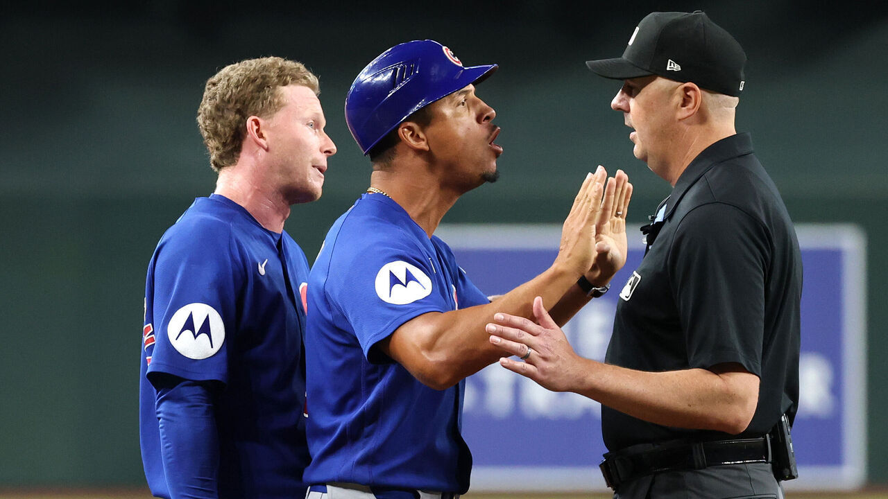 PHOENIX, ARIZONA - AUGUST 26: Pete Crow-Armstrong #4 and third base coach Quintin Berry #0 of the Chicago Cubs react at second base umpire Lance Barrett #16 during the sixth inning against the Arizona Diamondbacks at Chase Field on August 26, 2026 in Phoenix, Arizona.