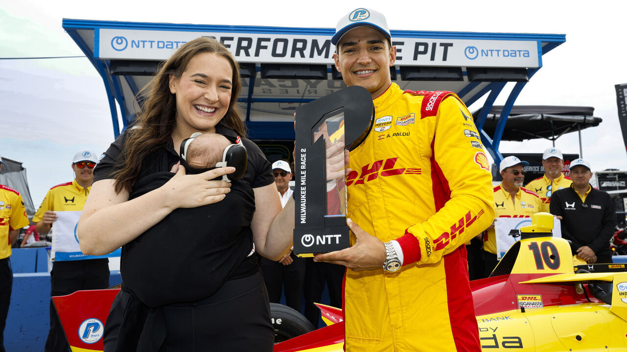 WEST ALLIS, WISCONSIN - AUGUST 29: NTT P1 Award winner #10: Alex Palou, Chip Ganassi Racing Honda celebrates his pole run and receives the P1 Award Trophy from Anna Osburn of NTT Data during the NTT INDYCAR Series Milwaukee Mile on August 29, 2026 at the Milwaukee Mile in West Allis, Wisconsin