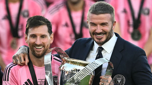 TOPSHOT - Inter Miami's Argentine forward #10 Lionel Messi (L) poses with the trophy next to the team's owner David Beckham (R) after winning the Major League Soccer (MLS) Cup final between Inter Miami and the Vancouver Whitecaps at Chase Stadium in Fort Lauderdale, Florida, on December 6, 2025.