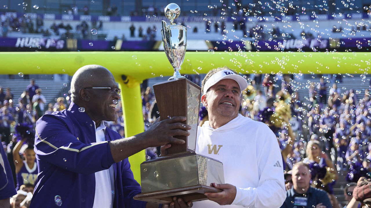 SEATTLE, WASHINGTON - SEPTEMBER 06: Jedd Fisch of the Washington Huskies lifts the Apple Cup trophy after then game against the Washington State Cougars at Husky Stadium on September 6, 2026 in Seattle, Washington.