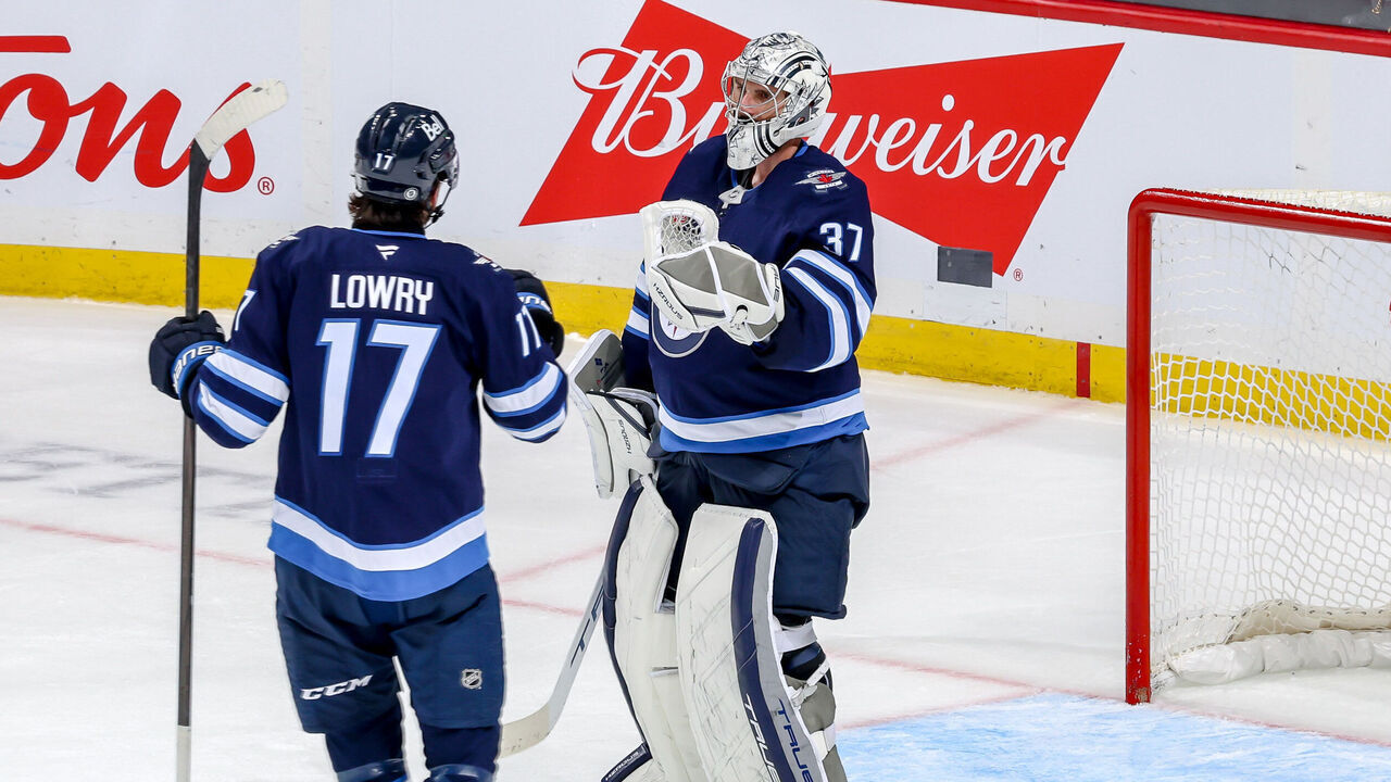 WINNIPEG, CANADA - NOVEMBER 3: Adam Lowry #17 of the Winnipeg Jets congratulates goaltender Connor Hellebuyck #37 following a 7-4 victory over the Tampa Bay Lightning at the Canada Life Centre on November 3, 2024 in Winnipeg, Manitoba, Canada.