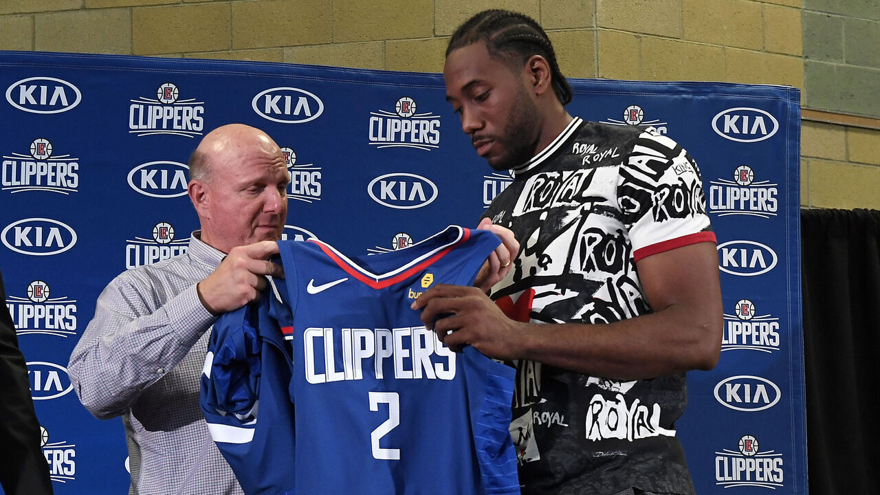 LOS ANGELES, CALIFORNIA - JULY 24: Los Angeles Clippers owner Steve Ballmer hands Kawhi Leonard his jersey as he and Paul George are introduced at Green Meadows Recreation Center on July 24, 2019 in Los Angeles, California.