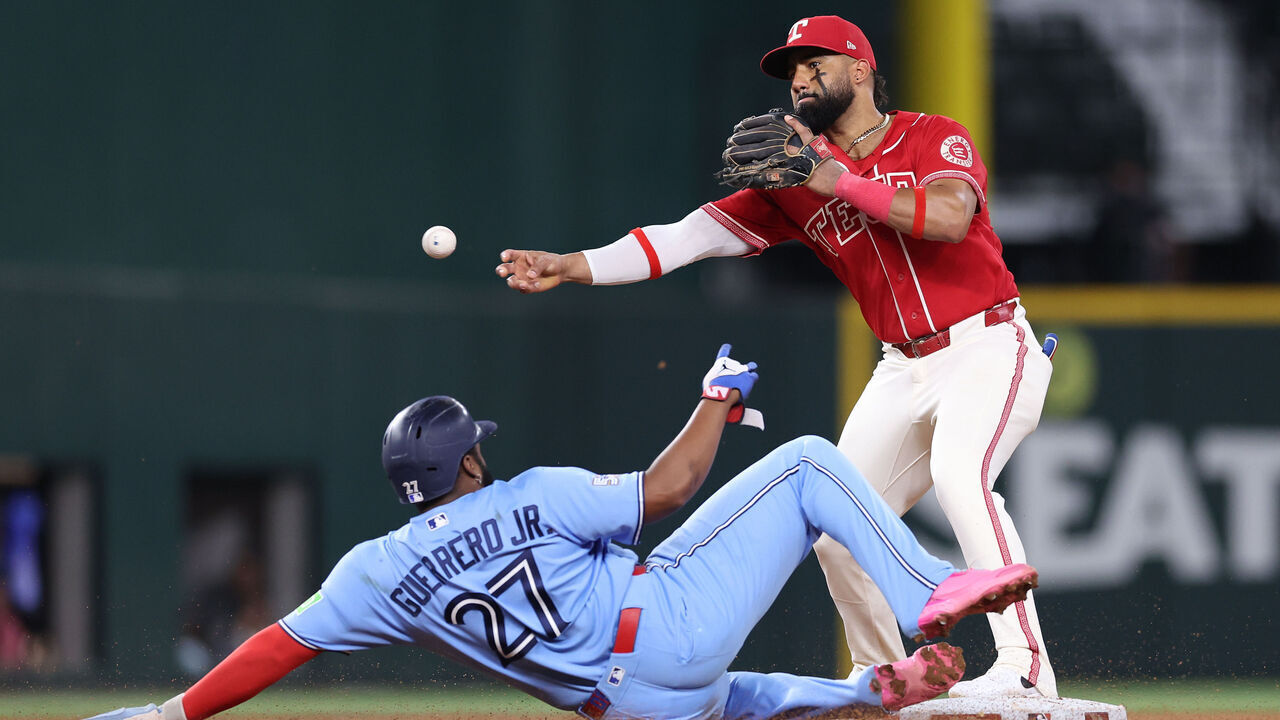 ARLINGTON, TEXAS - SEPTEMBER 19: Ezequiel Duran #20 of the Texas Rangers throws to first over Vladimir Guerrero Jr. #27 of the Toronto Blue Jays during the fourth inning at Globe Life Field on September 19, 2026 in Arlington, Texas.