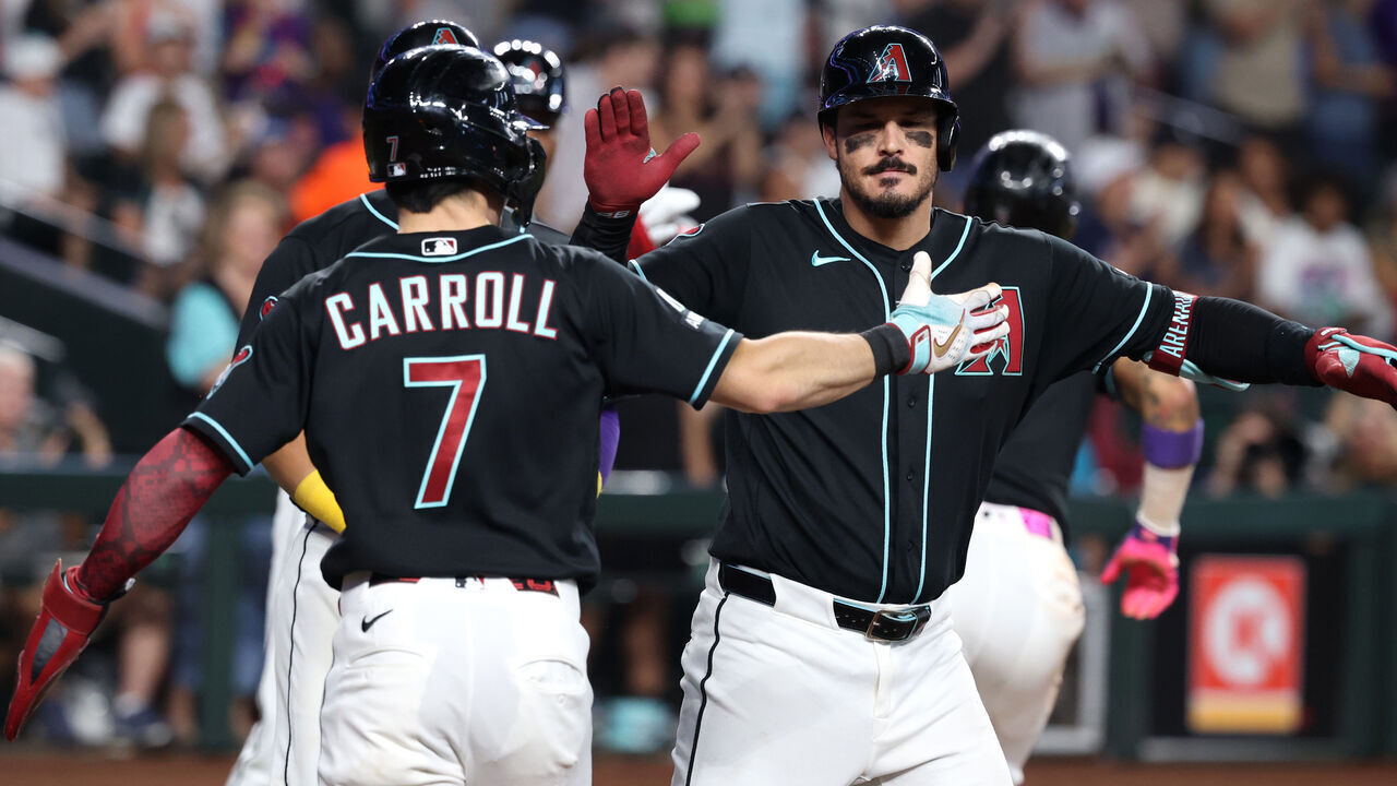 PHOENIX, ARIZONA - SEPTEMBER 20: Nolan Arenado #28 high fives Corbin Carroll #7 of the Arizona Diamondbacks after hitting a grand slam against the New York Yankees during the fifth inning at Chase Field on September 20, 2026 in Phoenix, Arizona.
