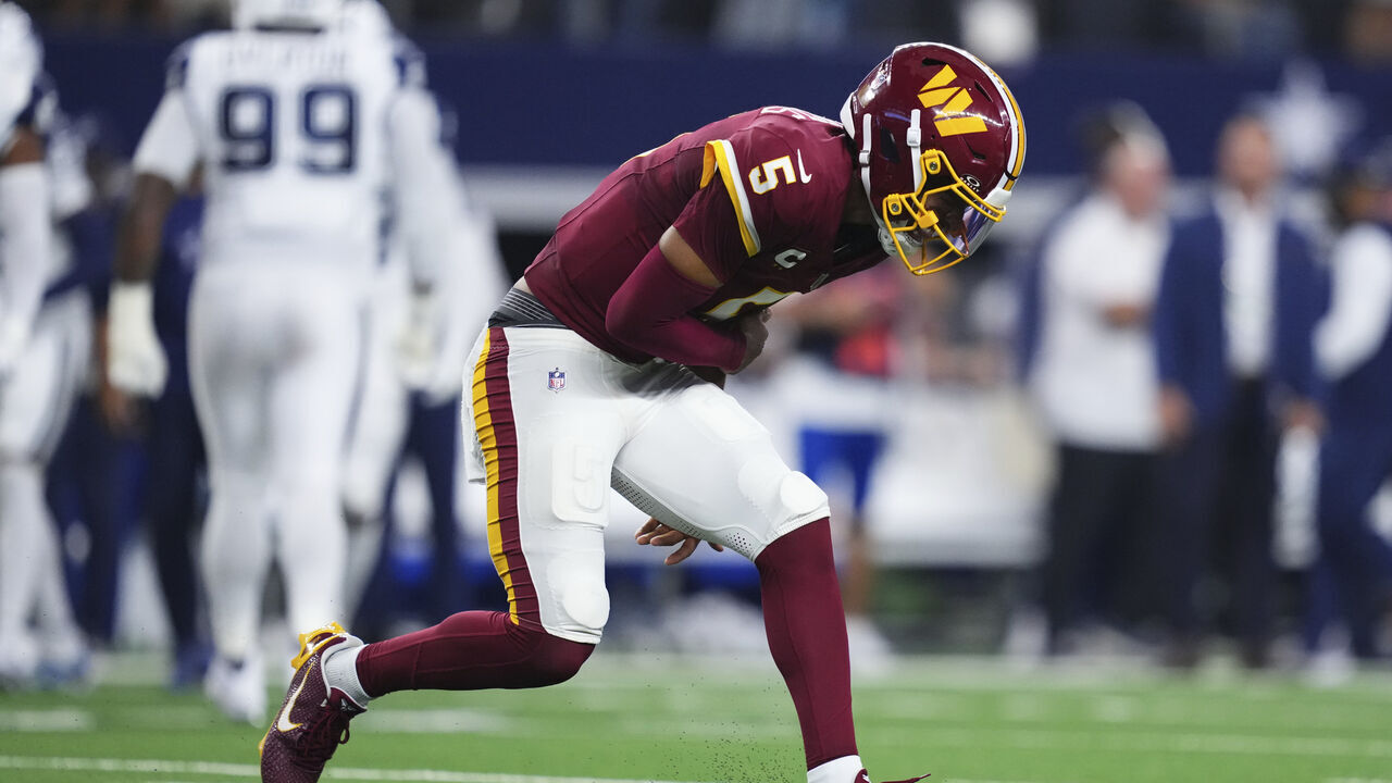 ARLINGTON, TX - SEPTEMBER 20: Jayden Daniels #5 of the Washington Commanders reacts after a play against the Dallas Cowboys during the first half of an NFL football game at AT&T Stadium on September 20, 2026 in Arlington, Texas.