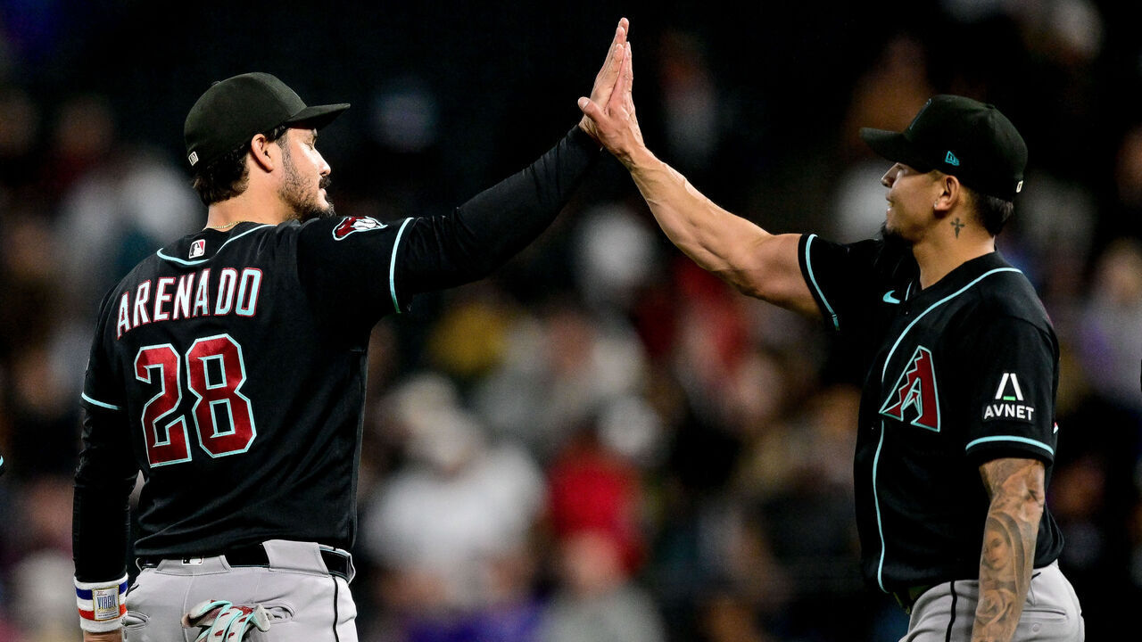 DENVER, CO - SEPTEMBER 23: Arizona Diamondbacks third baseman Nolan Arenado (28) and pitcher Jonathan Loáisiga (43) celebrate after a win in a game against the Colorado Rockies at Coors Field on September 23, 2026 in Denver, Colorado.