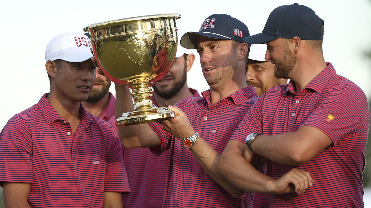MEDINAH, ILLINOIS - SEPTEMBER 27: Collin Morikawa of the U.S. Team, Justin Thomas of the U.S. Team and Wyndham Clark of the U.S. Team look at the trophy during the ceremony after their 17-13 win following the Sunday's Singles on day four of the Presidents Cup 2026 at Medinah Country Club on September 27, 2026 in Medinah, Illinois.