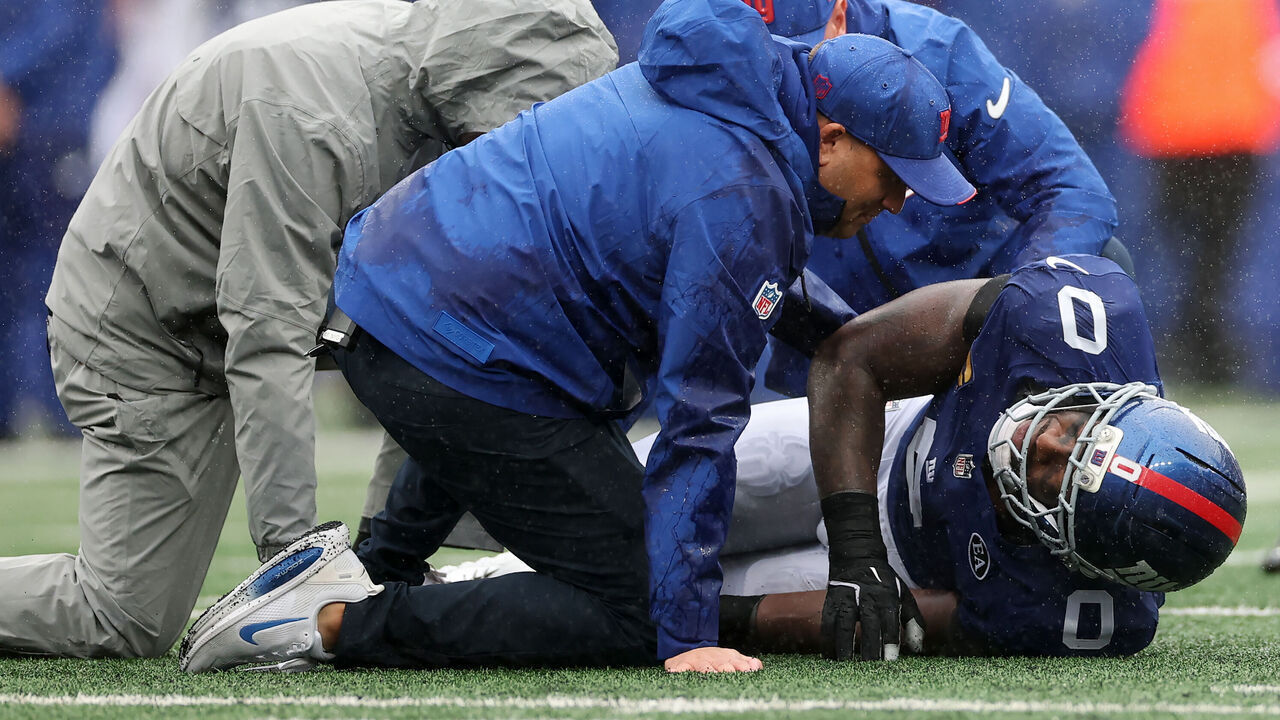 EAST RUTHERFORD, NEW JERSEY - SEPTEMBER 27: Brian Burns #0 of the New York Giants is tended to by the trainers against the Tennessee Titans during the fourth quarter at MetLife Stadium on September 27, 2026 in East Rutherford, New Jersey.