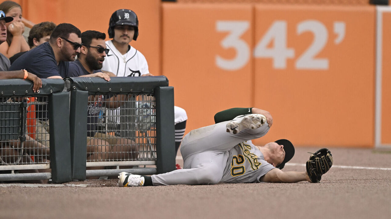 DETROIT, MI - JULY 09: Athletics left-fielder Zack Gelof (20) grabs his leg after sliding into the railing trying to catch a foul ball during game between Athletics and Detroit Tigers on July 9, 2026 at Comerica Park in Detroit, MI
