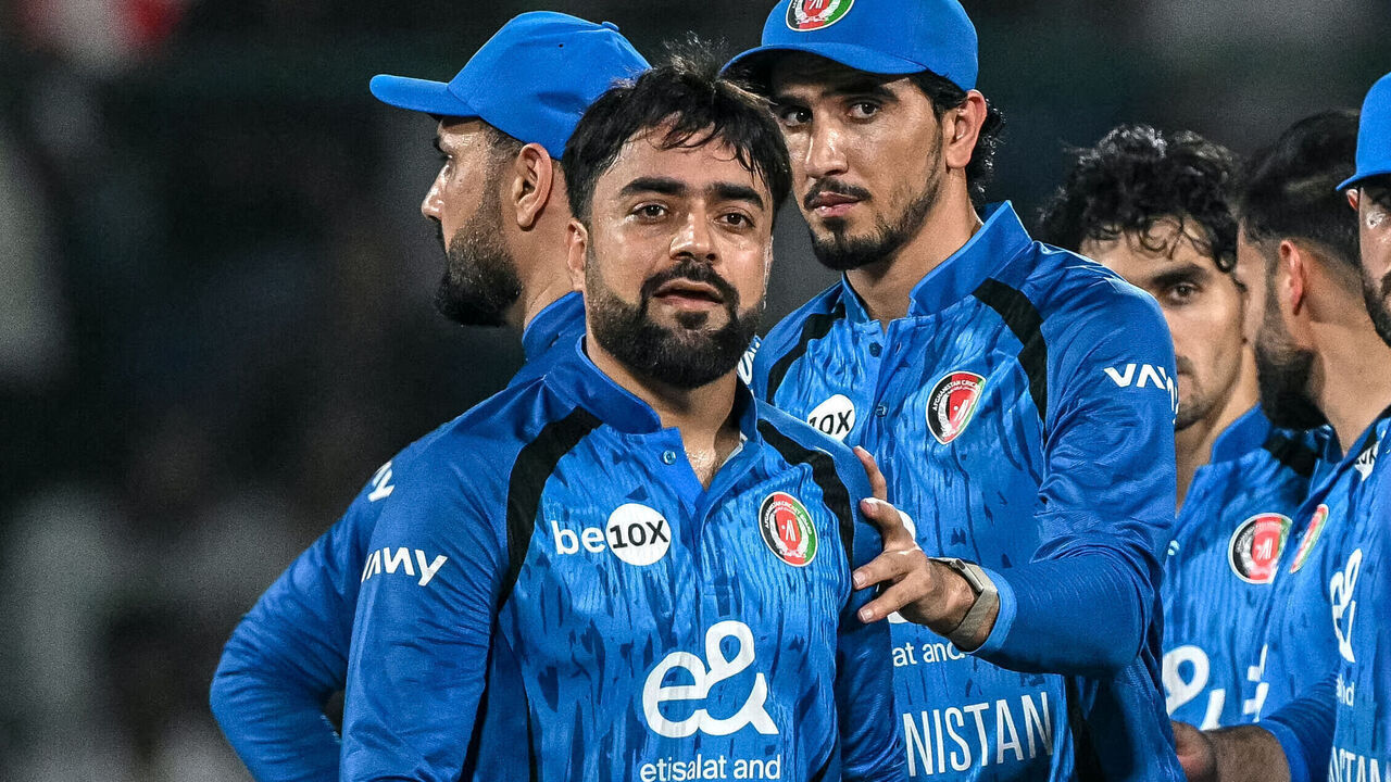 Afghanistan's Rashid Khan (L) celebrates with teammates after taking the wicket of India's Abhishek Sharma (R) during the third T20 international cricket match between India and Afghanistan at the Arun Jaitley Stadium in New Delhi on September 17, 2026. / -- IMAGE RESTRICTED TO EDITORIAL USE - STRICTLY NO COMMERCIAL USE --